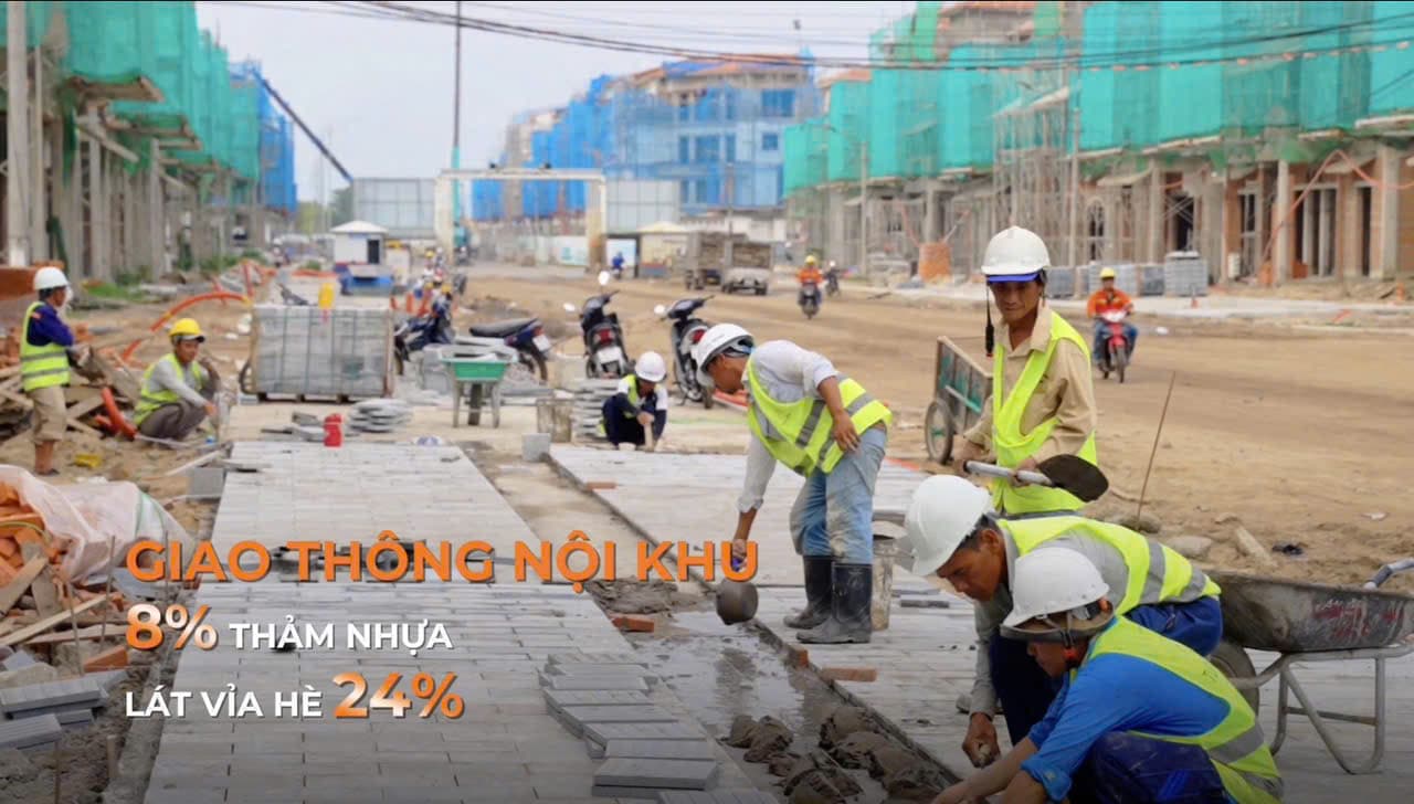 Công nhân lát gạch vỉa hè trên tuyến đường nội khu giữa hai dãy nhà đang xây