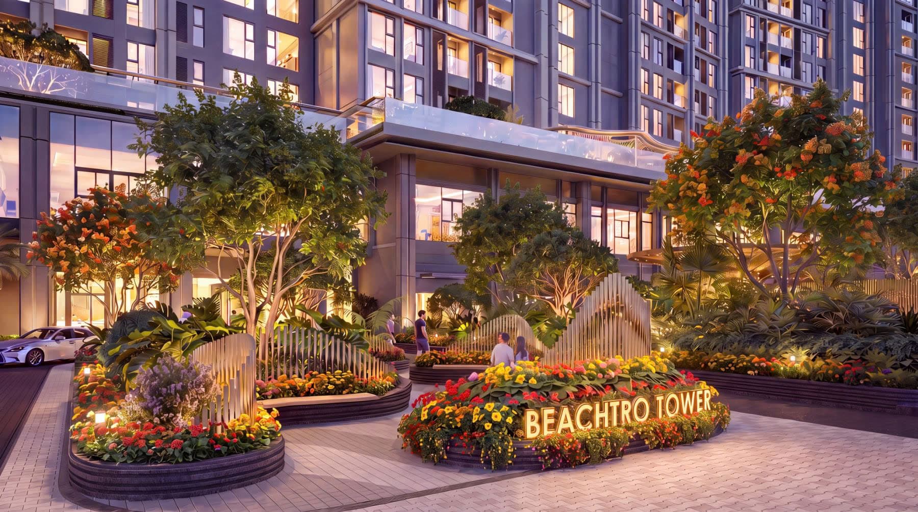 Sảnh đón tòa Beachtro Tower lúc chạng vạng với vườn hoa và cây xanh chiếu sáng